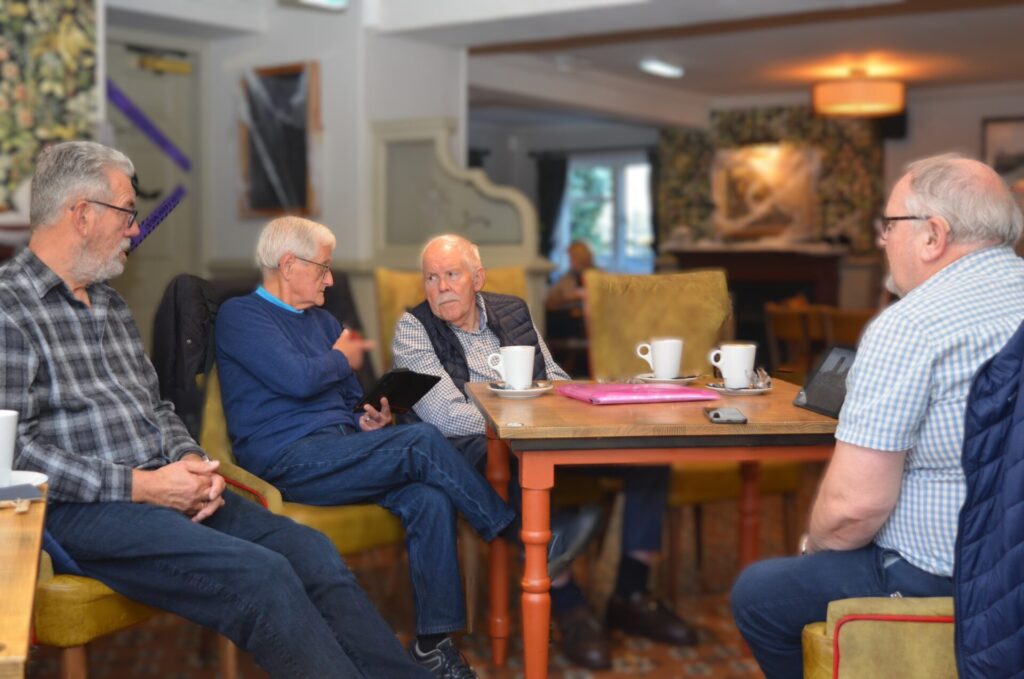 Photography group members discussing photographs at their monthly meeting in the Cross Keys.